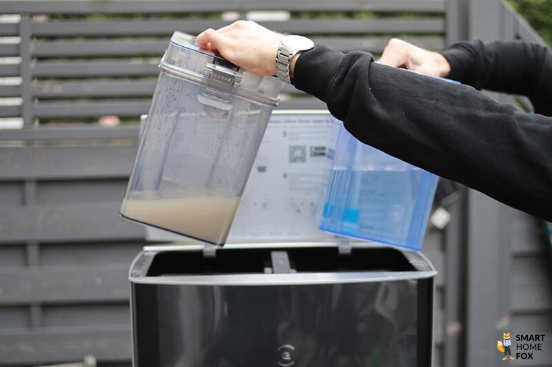 Der Frischwassertank und der Schmutzwassertank des Ecovacs Deebot X1 OMNI werden in den Händen gehalten